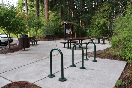 Parking area with garbage can, bike rack, bench, picnic tables and kiosk